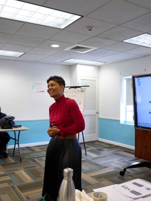 A woman is smiling teaching a class.