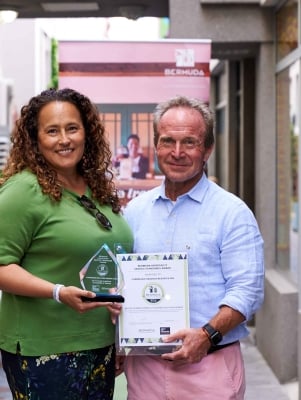 Two people are posing with an award