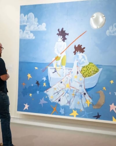 A man is standing in front of Art 