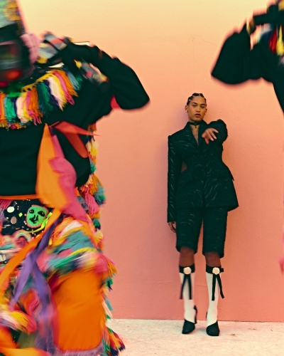 Model wearing Bermuda shorts with Bermuda Gombey dancers in foreground