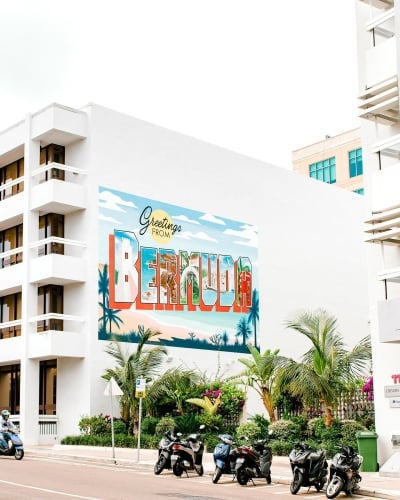 A sign painted on the side of a building that says "Greetings from Bermuda".