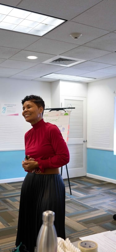 A woman is smiling teaching a class.